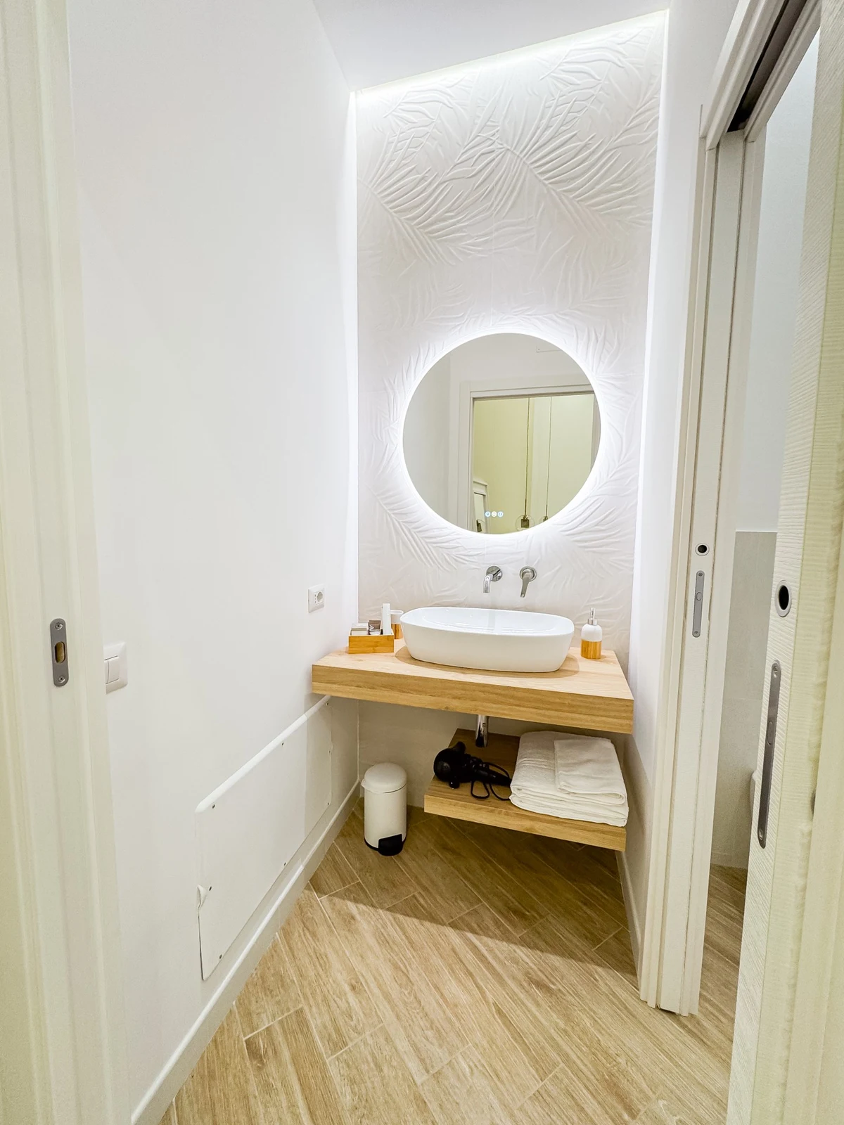 Il lavabo della camera Edith Piaf, in una nicchia con specchio tondo illuminato