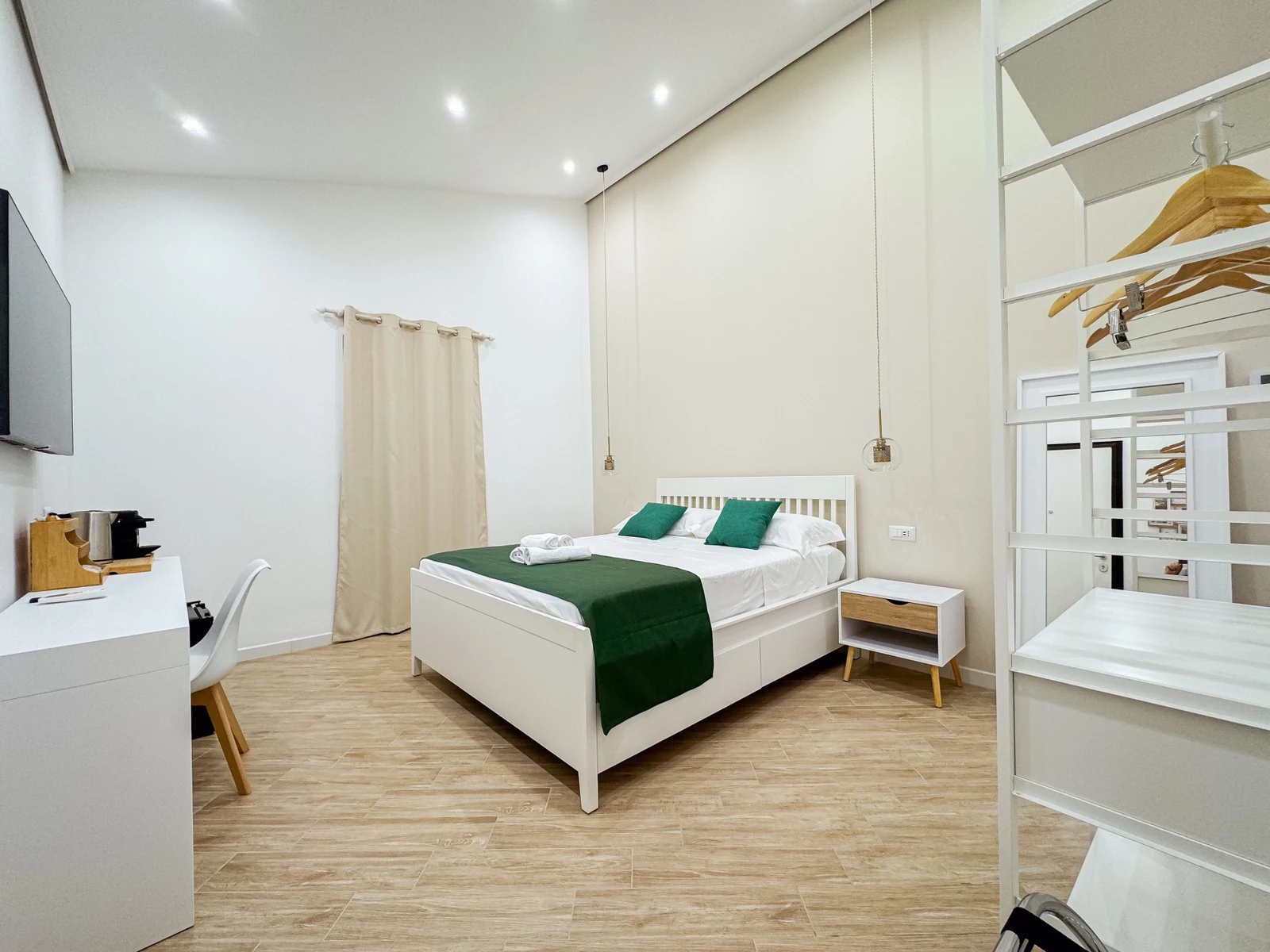 La camera Edith Piaf: letto matrimoniale con copriletto verde, scrivania e armadio aperto