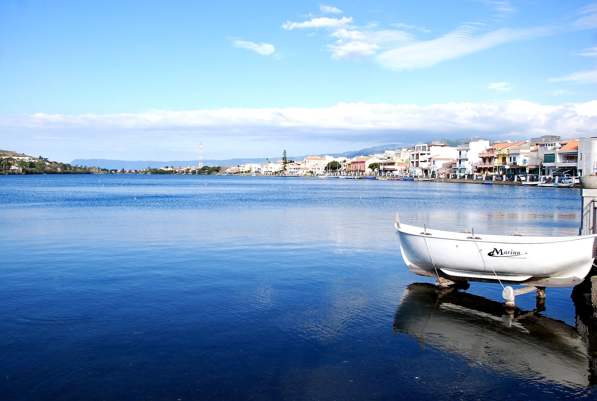 Il Lago di Ganzirri, con una barca tirata in secca e il paese sulla riva opposta